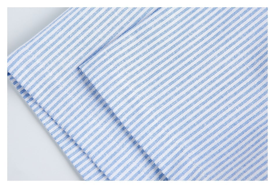 Close-up of blue-and-white striped fabric with a diagonal stitched seam.