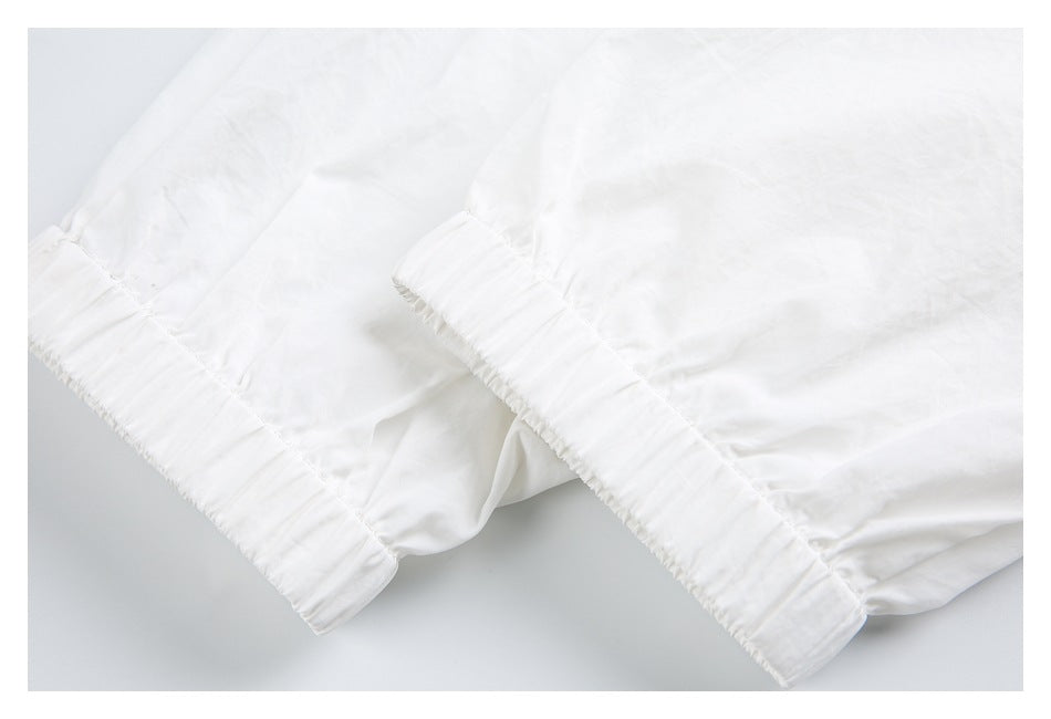 Close-up of two white elasticated jacket cuffs.