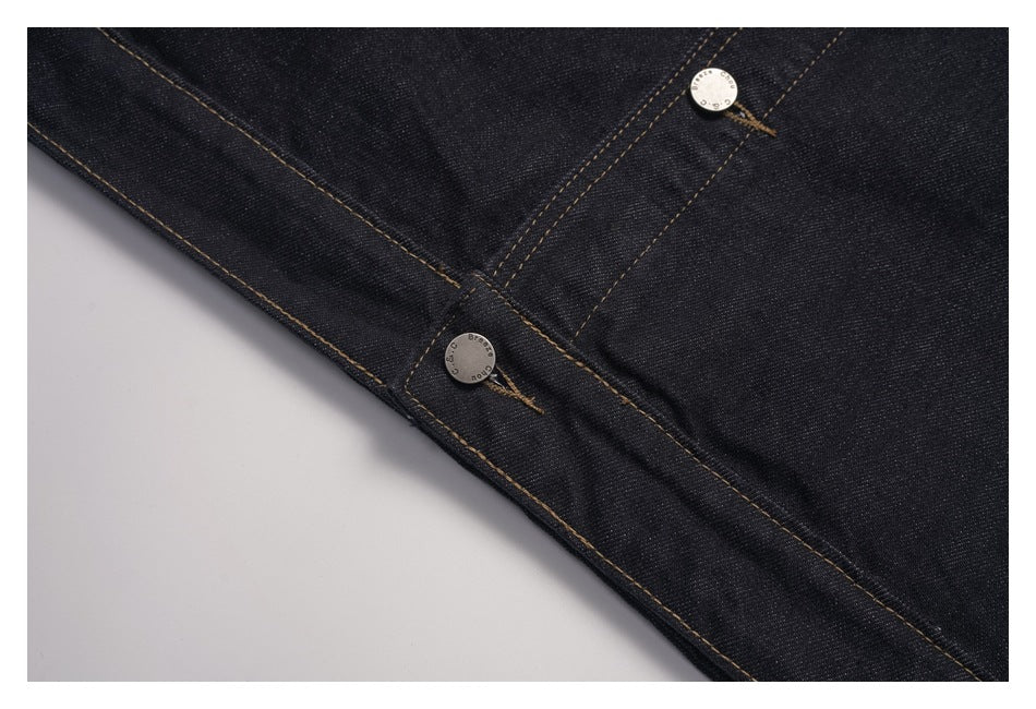 Close-up of the dark denim jacket front placket with two metal buttons and contrast stitching.