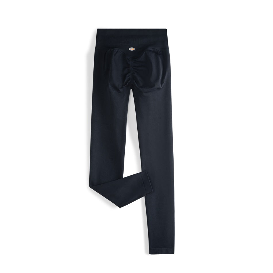 Back view of dark navy full-length leggings with a wide high-rise waistband and ruched seat seams.