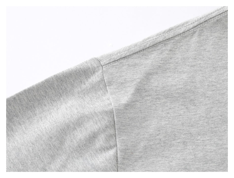Close-up of the gray T-shirt's shoulder seam and short sleeve construction.