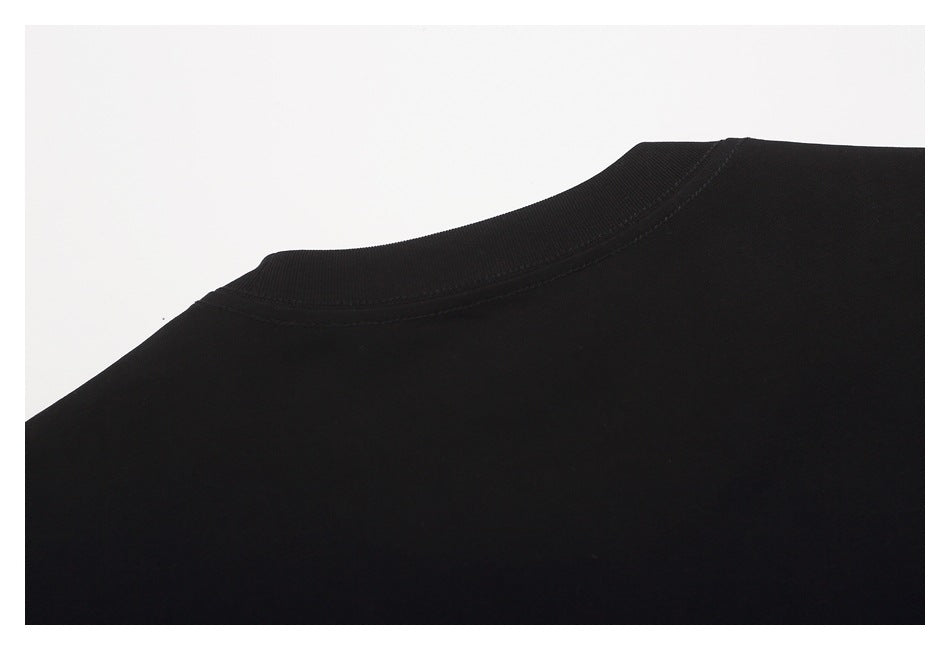 Close-up of the black T-shirt's crew neckline and shoulder stitching.