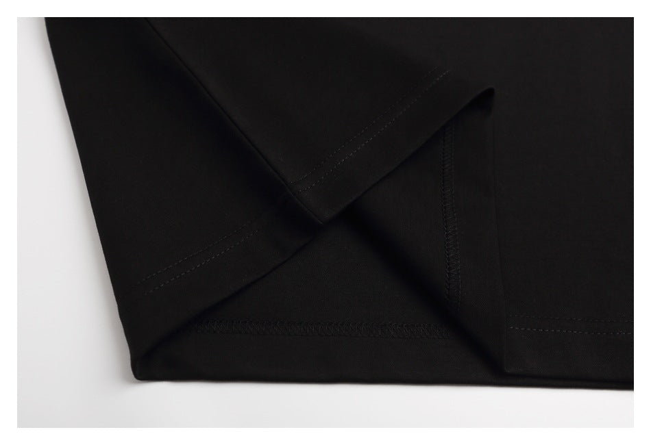 Close-up of the black T-shirt's sleeve and body stitching and hem construction.