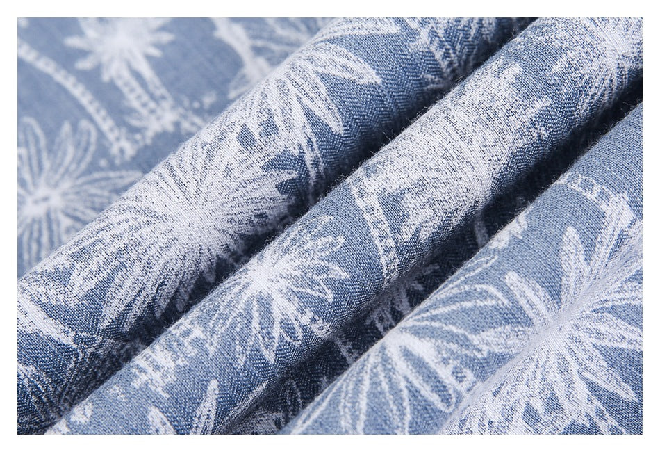 Close-up of folded blue fabric with a white floral and paisley pattern.