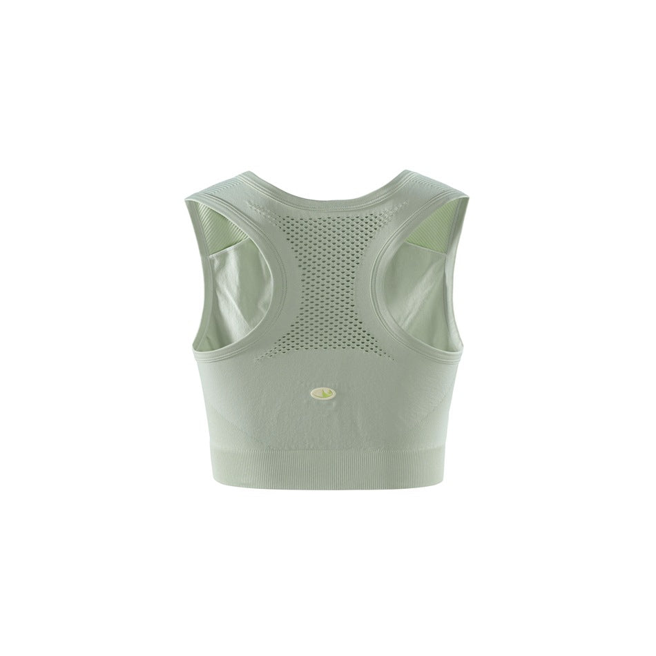Back view of a pale sage-green cropped sports bra with a perforated racerback panel and wide ribbed hem.