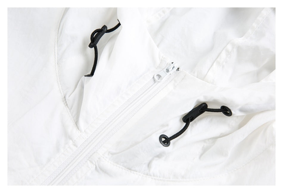 Close-up of a white jacket's zipper and black hood drawcords with metal eyelets.
