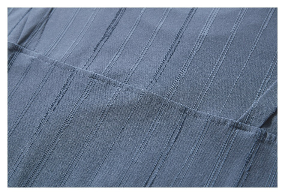 Close-up of the blue-gray top's vertical stripe texture and stitched seam.