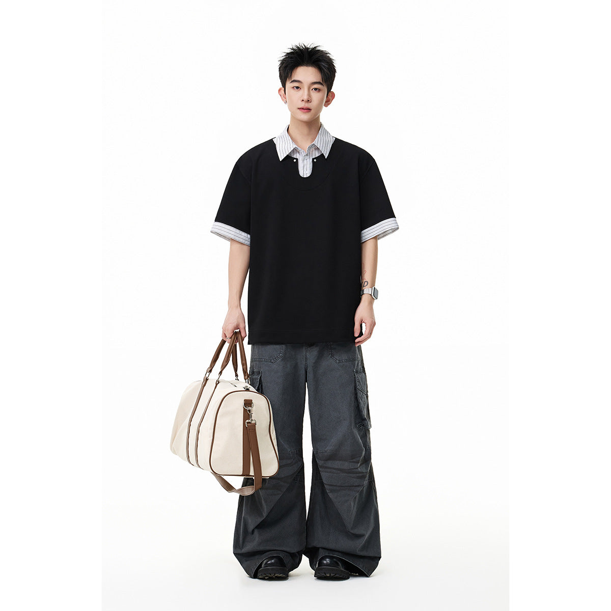 Model wearing an oversized black short-sleeve top layered over a white pinstriped collared shirt, with dark cargo pants.