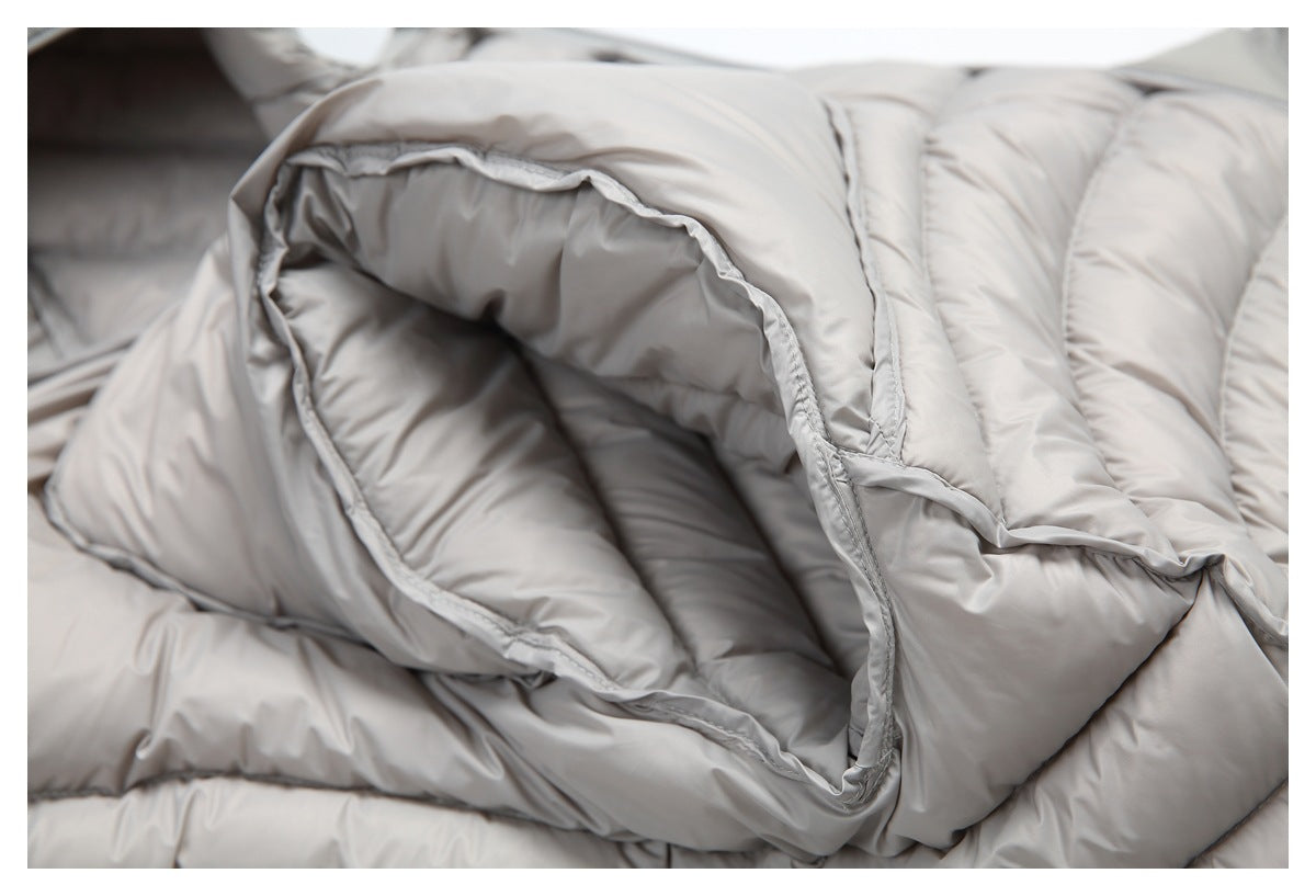 Close-up of a large opening between padded sections of a light gray quilted jacket.