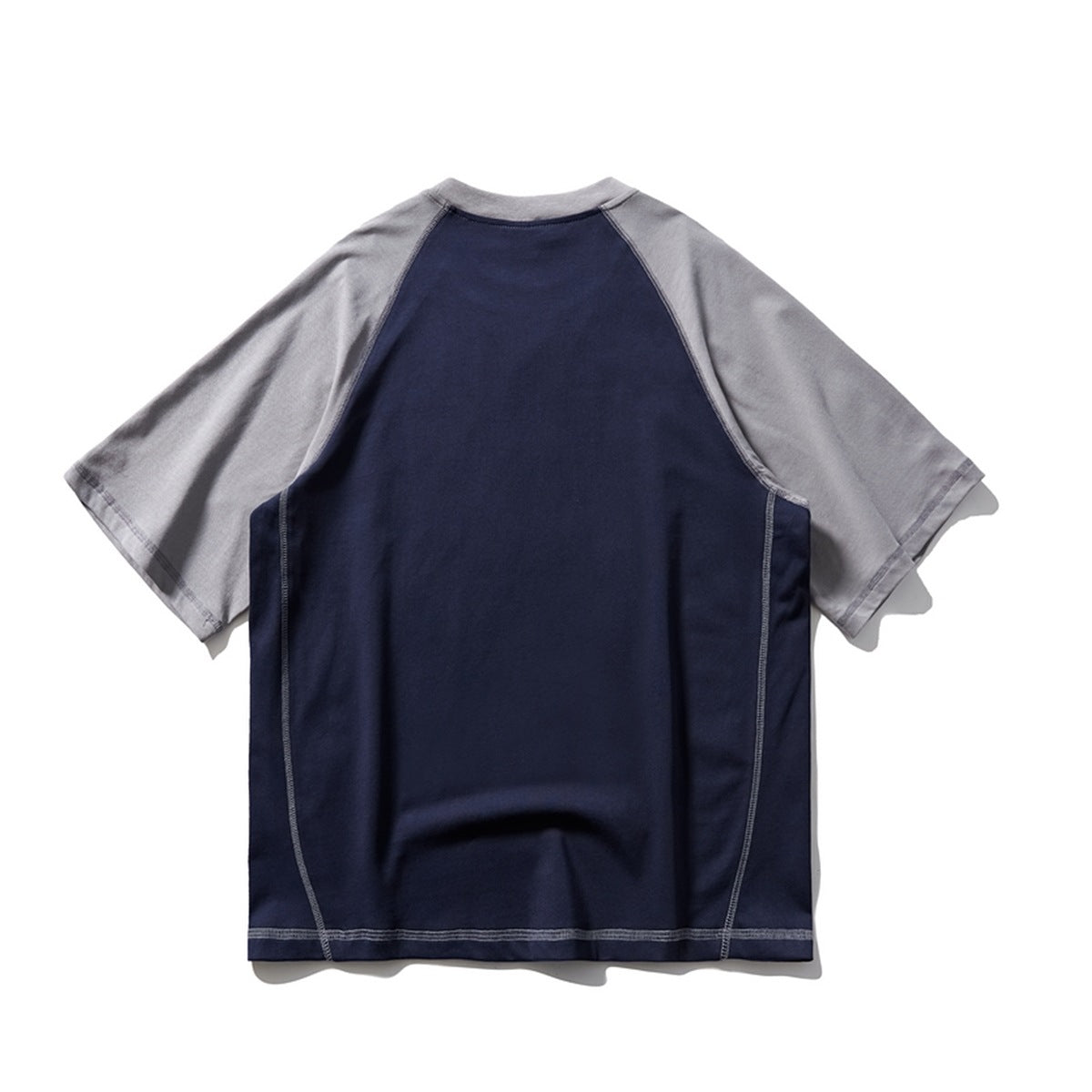 Back view of navy raglan T-shirt with gray sleeves and contrast topstitching on side panels and hem