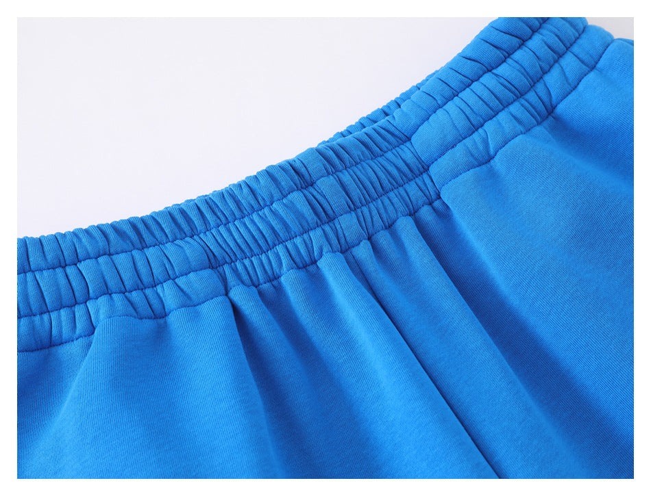 Close-up of bright blue pants showing the gathered elastic waistband and fabric folds.