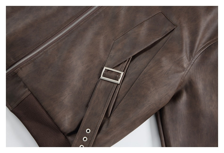 Close-up of a jacket pocket with a narrow buckle strap, metal eyelets, and the front zipper.