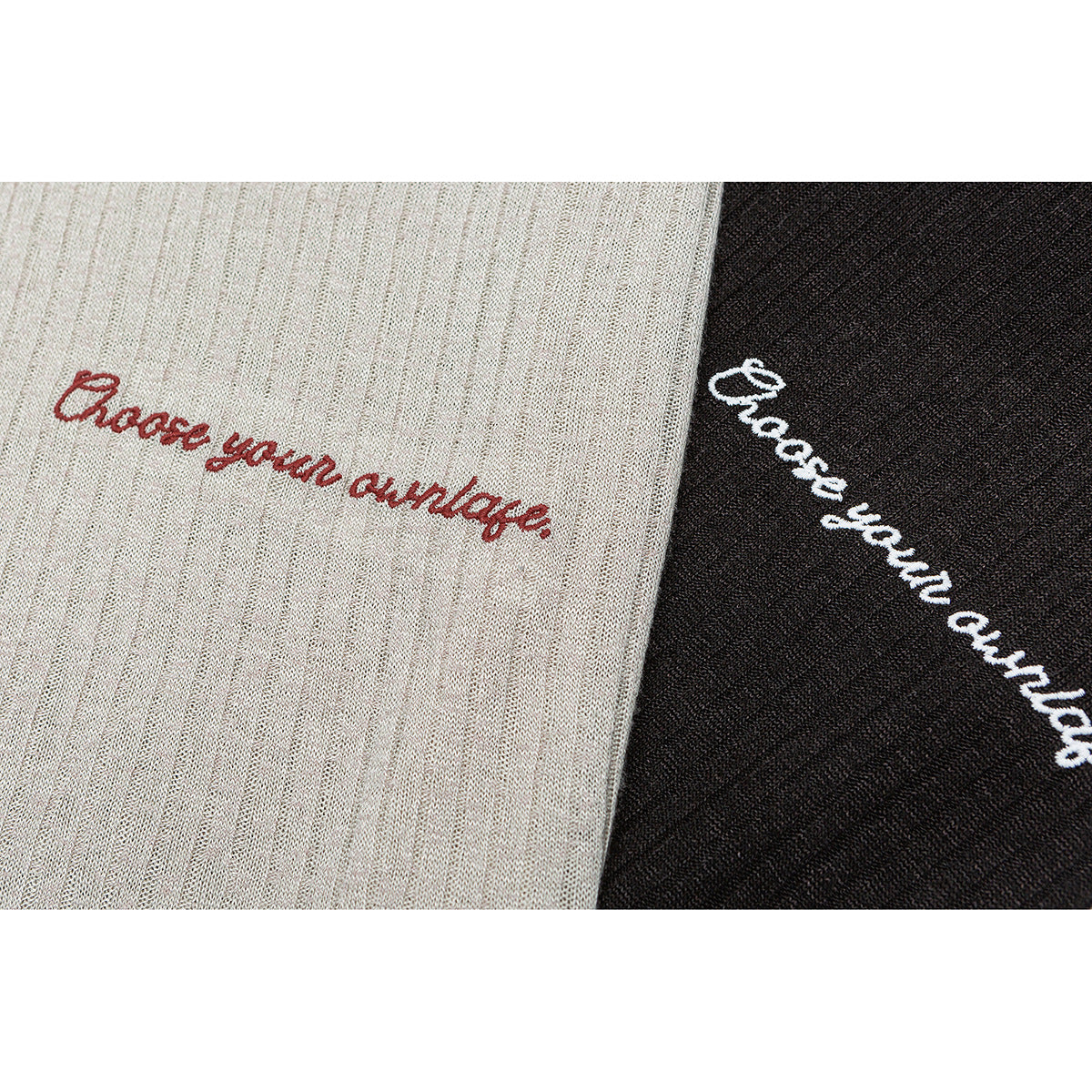 Close-up of cream and black ribbed knit fabric with embroidered “Choose your vintage” lettering.