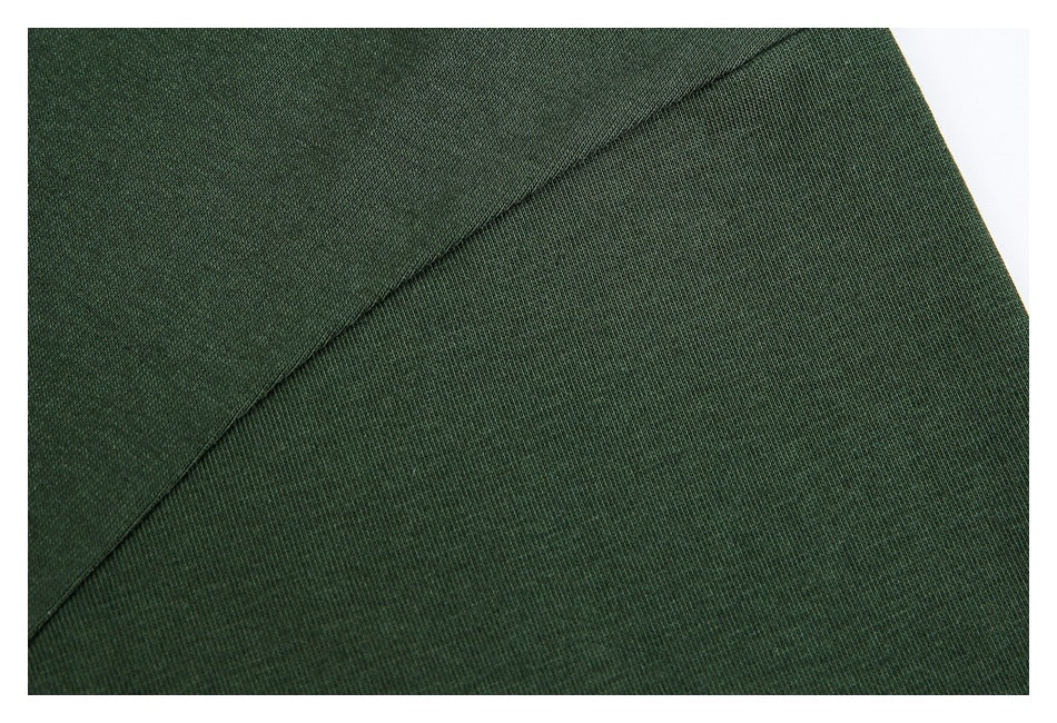 Close-up of dark green fabric and a curved stitched seam.
