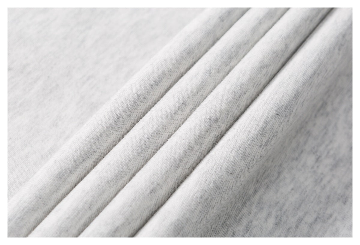 Close-up of light gray fabric arranged in soft folds, showing a fine knit texture.