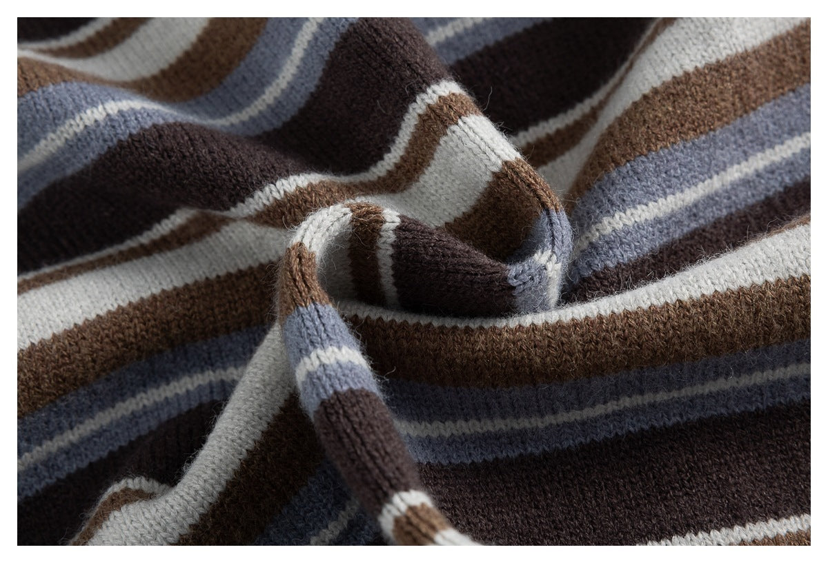 Close-up of the striped knit sweater fabric folded to show its soft-looking texture and color bands.