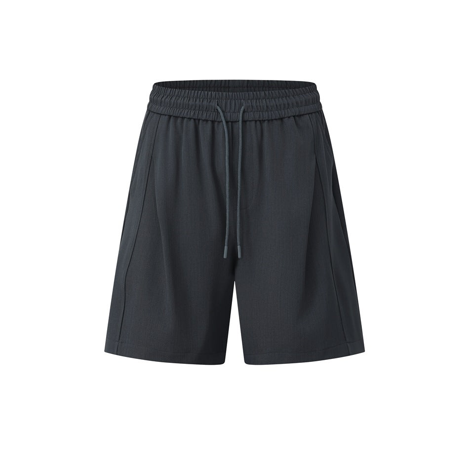 Dark charcoal gray drawstring shorts with elastic waistband and front pleat seams, flat front view