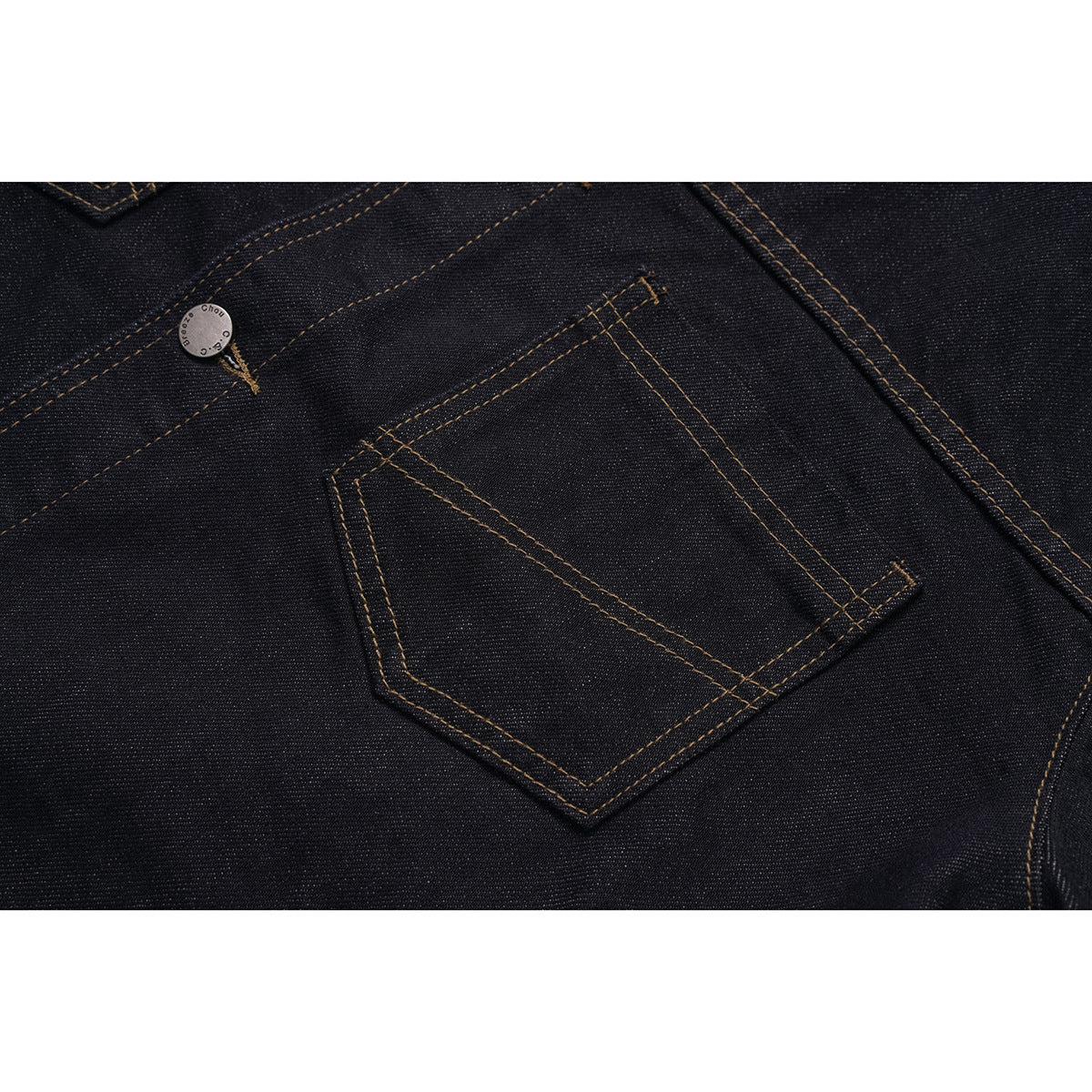 Close-up of a dark indigo jacket's angled chest pocket, contrast stitching and metal button.