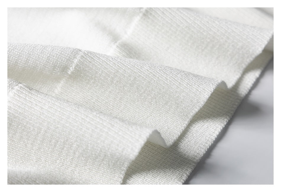 Close-up of the white sweater's knit texture and folded edge.