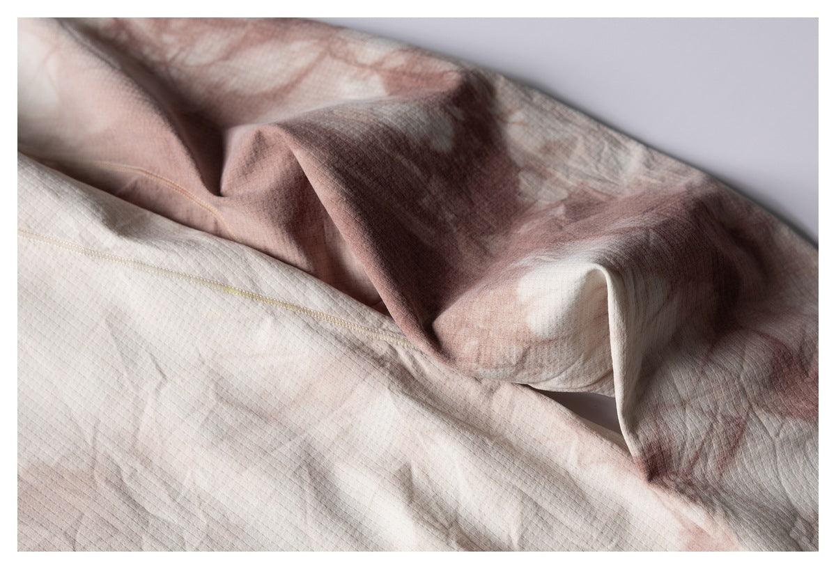 Close-up of the beige and brown mottled shirt fabric folded to show an interior stitched seam.