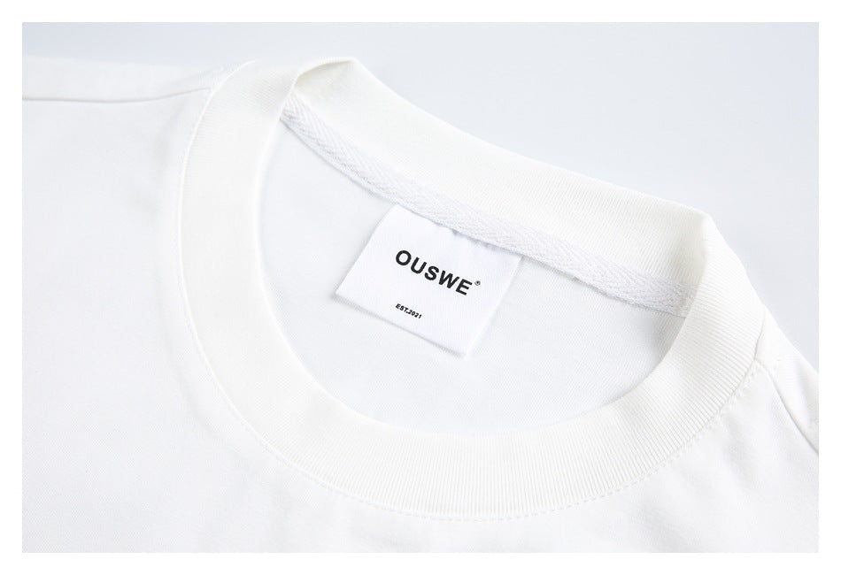 Close-up of a white T-shirt’s ribbed crew neck and sewn-in OUSWE label.