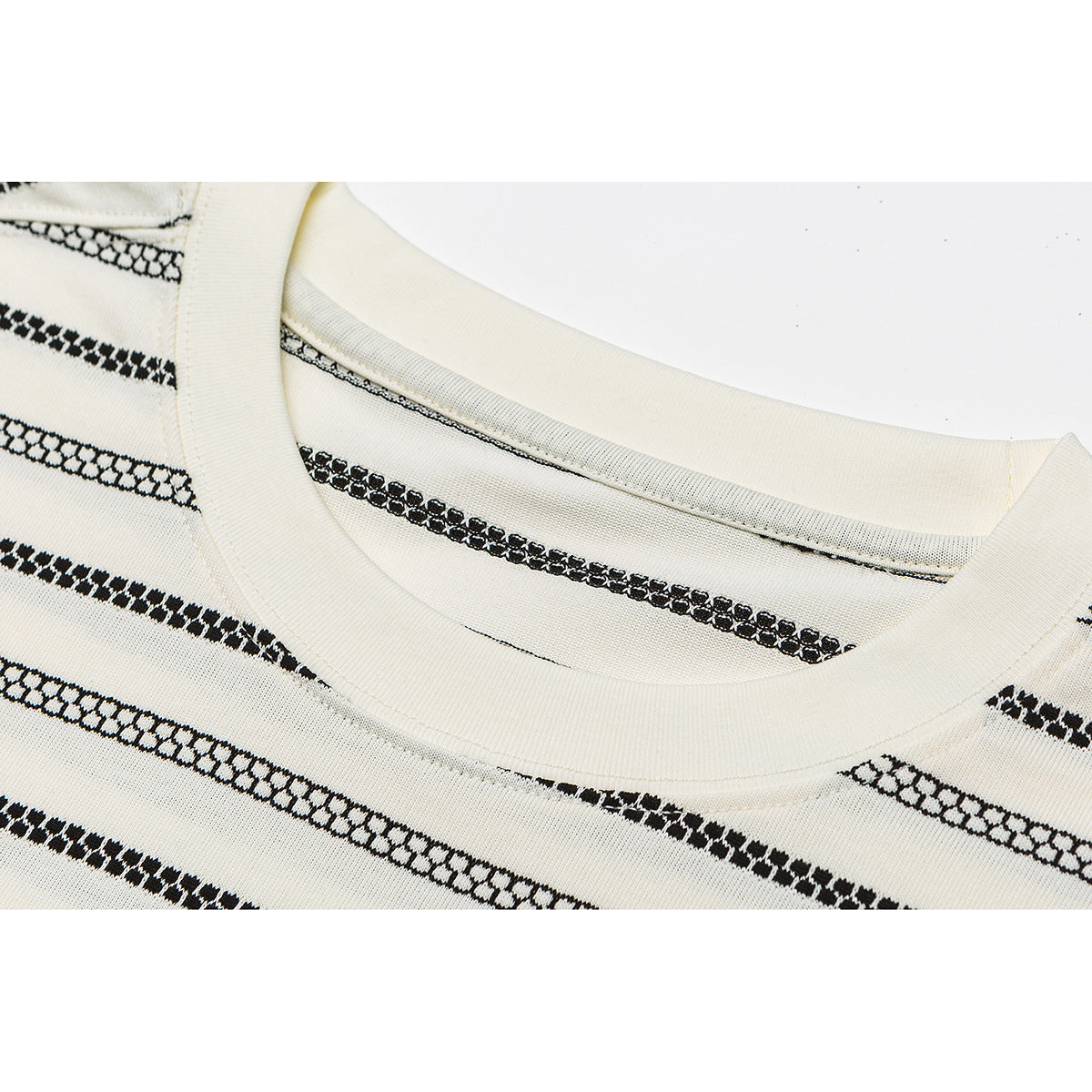 Close-up of an ivory T-shirt's ribbed crew neck and black patterned horizontal stripes.