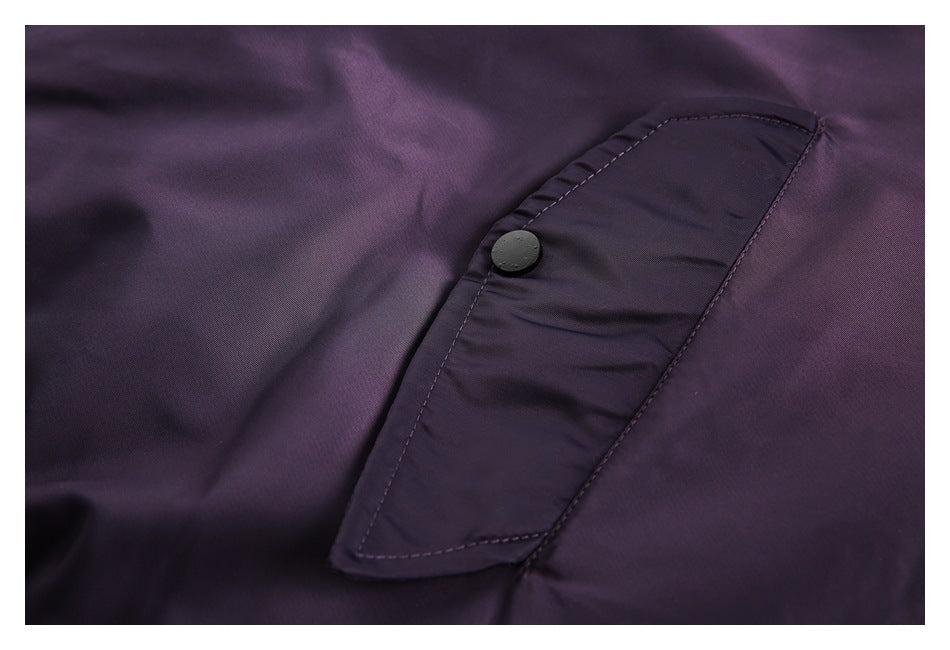 Close-up of a dark purple jacket pocket flap with a round dark button.