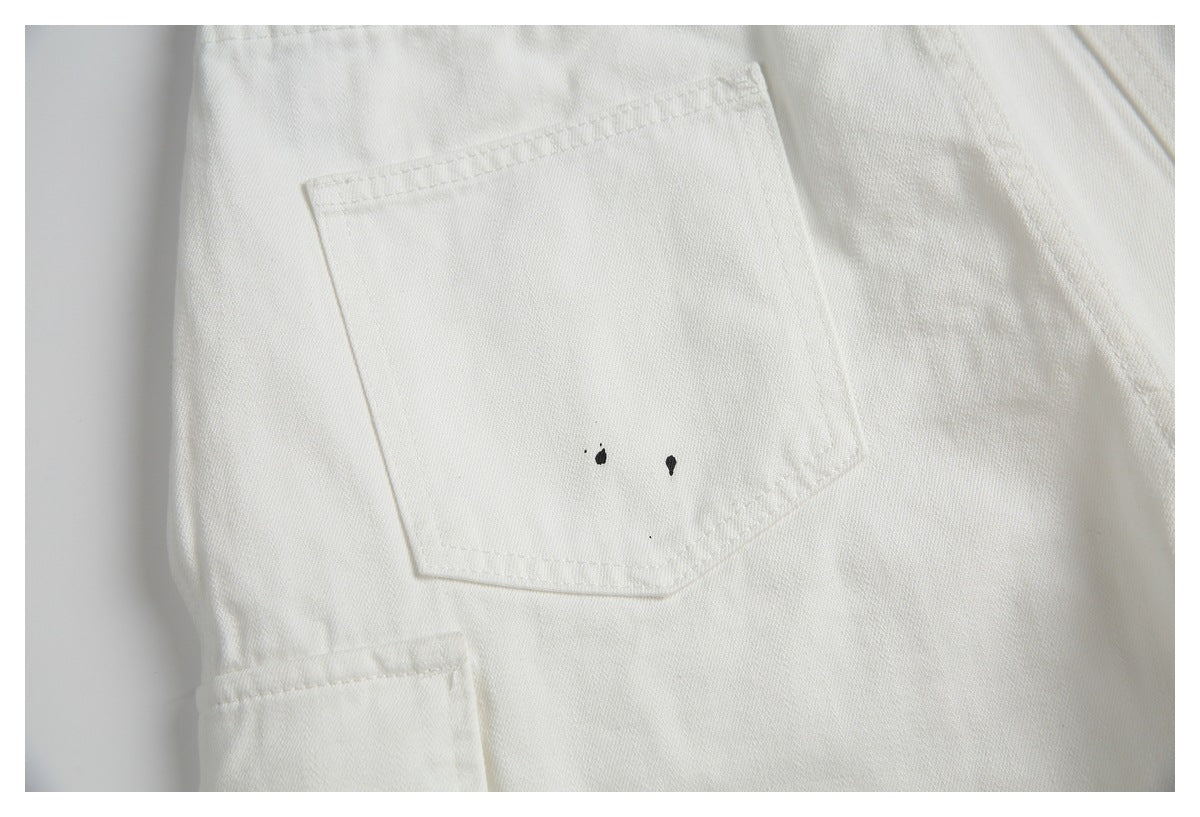Close-up of an off-white back pocket with two small black paint-like marks.