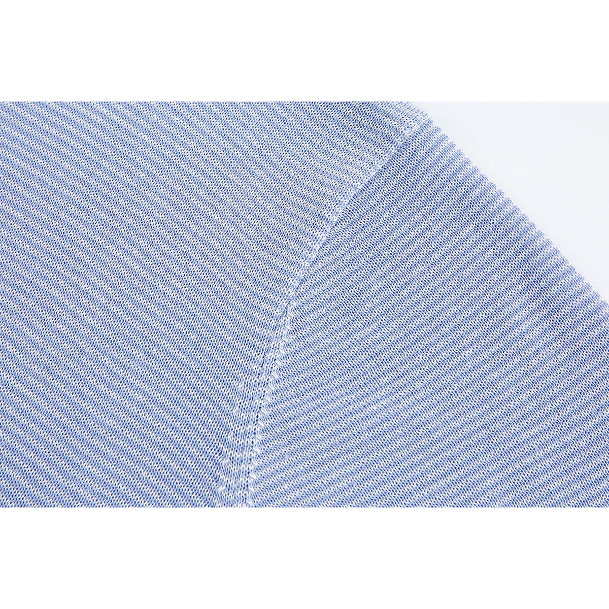 Close-up of blue-and-white knit fabric with a diagonal shoulder seam.