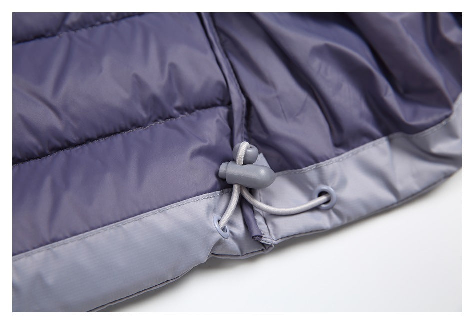 Close-up of the jacket hem drawcord, cord lock, and eyelets against purple-gray quilted fabric.