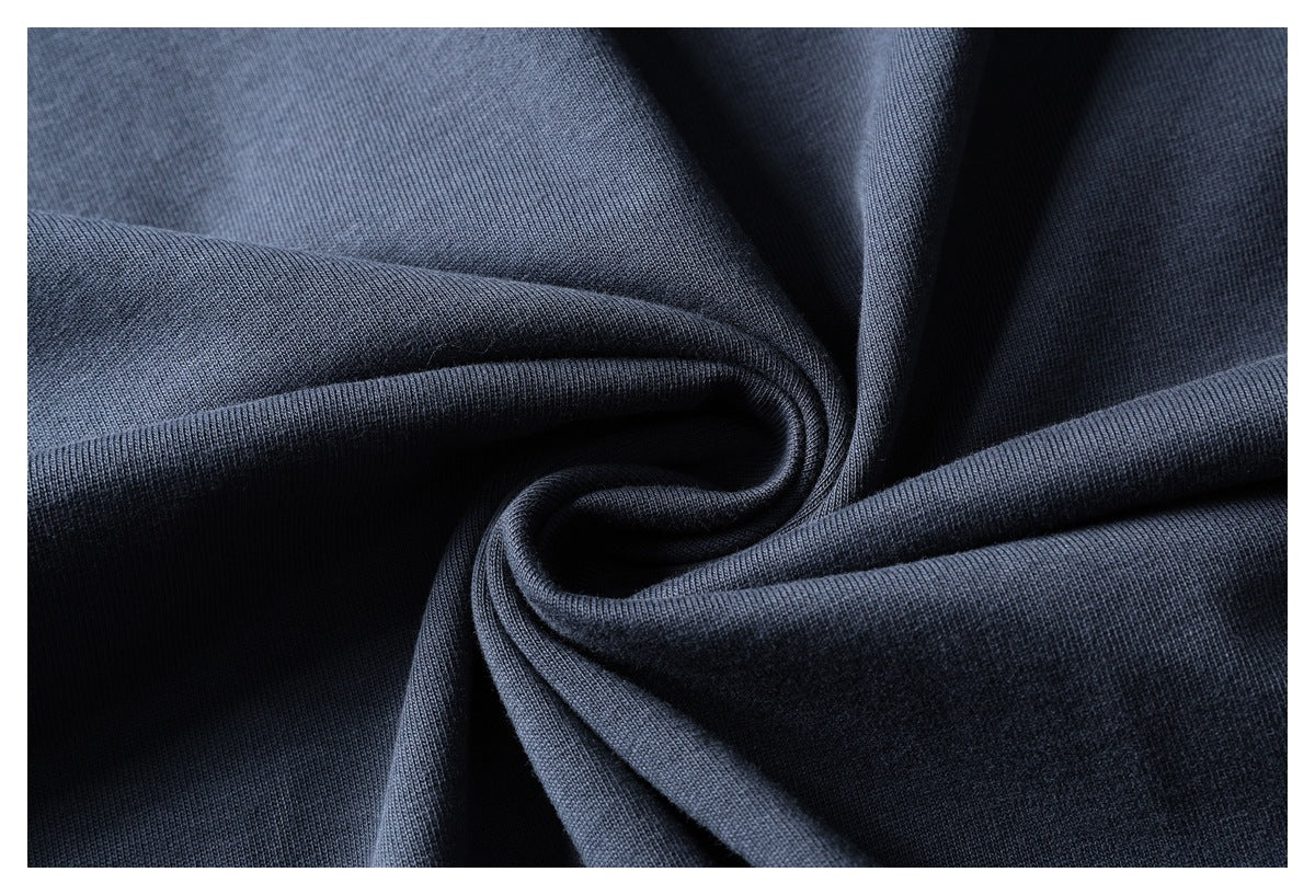 Close-up of dark navy fabric draped into folds, showing its surface texture.