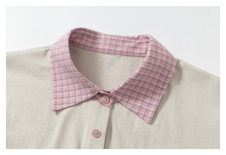 Close-up of the cream polo’s pink plaid collar, pink buttons, and front placket.