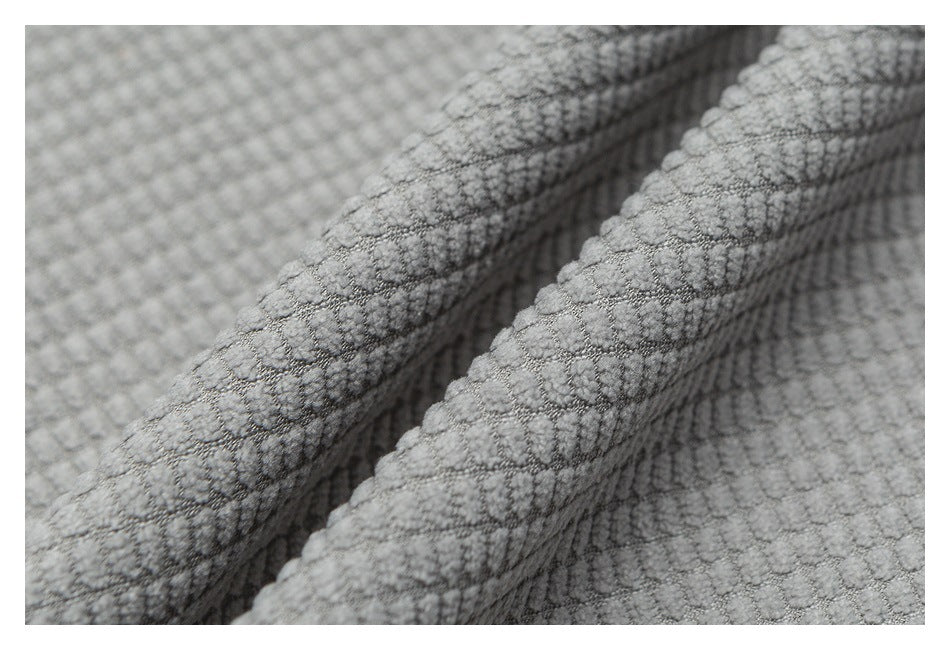 Close-up of folded gray fabric showing a raised, grid-like textured surface.