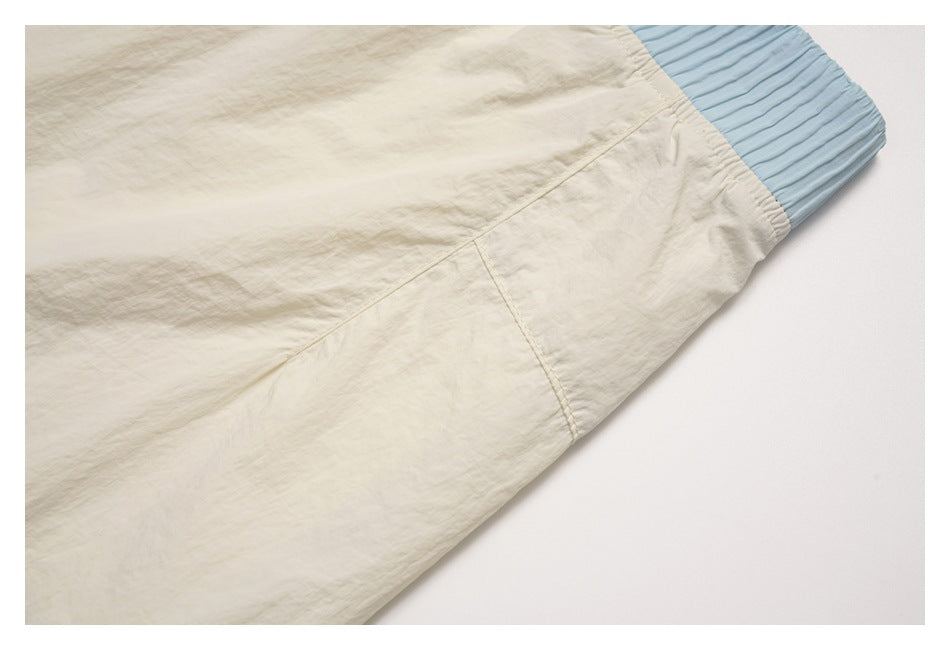 Close-up of an off-white garment seam beside a light blue ribbed cuff.