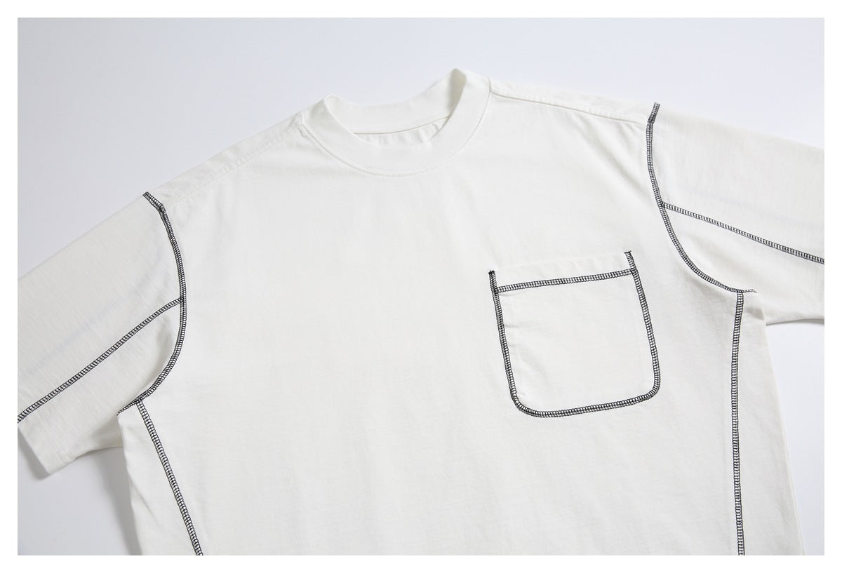 Front close-up of an off-white short-sleeve T-shirt with a chest pocket and dark contrast stitching.