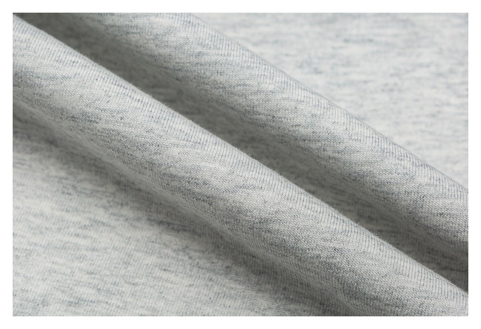 Macro view of the light gray heather knit fabric, draped to show its texture.