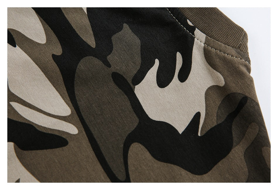 Close-up of a black, brown, and beige camouflage garment showing a stitched neckline and shoulder seam.