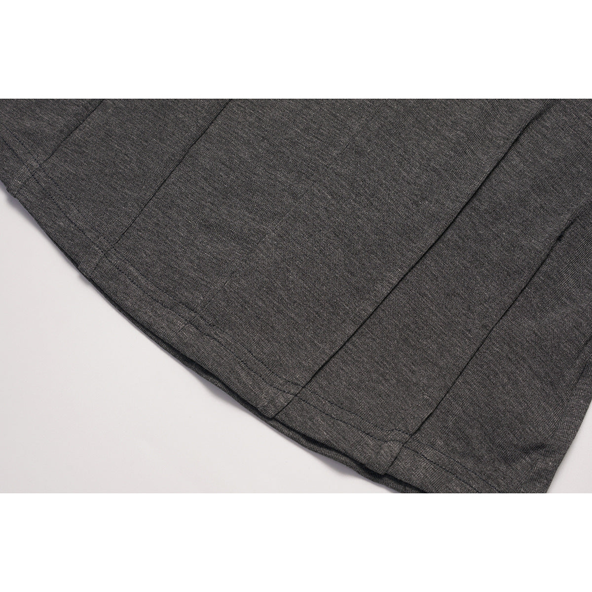 Close-up of charcoal gray knit fabric showing panel seams and a stitched hem.