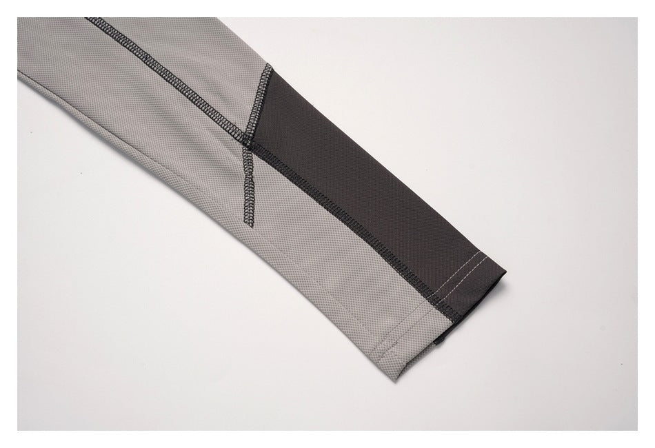 Close-up of a gray sleeve cuff with a dark contrast panel and visible stitching.