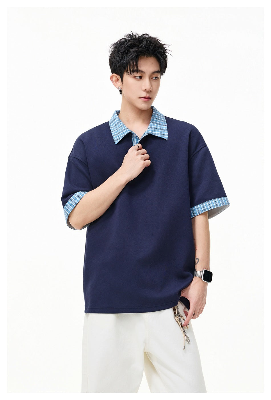 Model wearing a navy short-sleeve shirt with a blue plaid collar and matching turned-up cuffs.