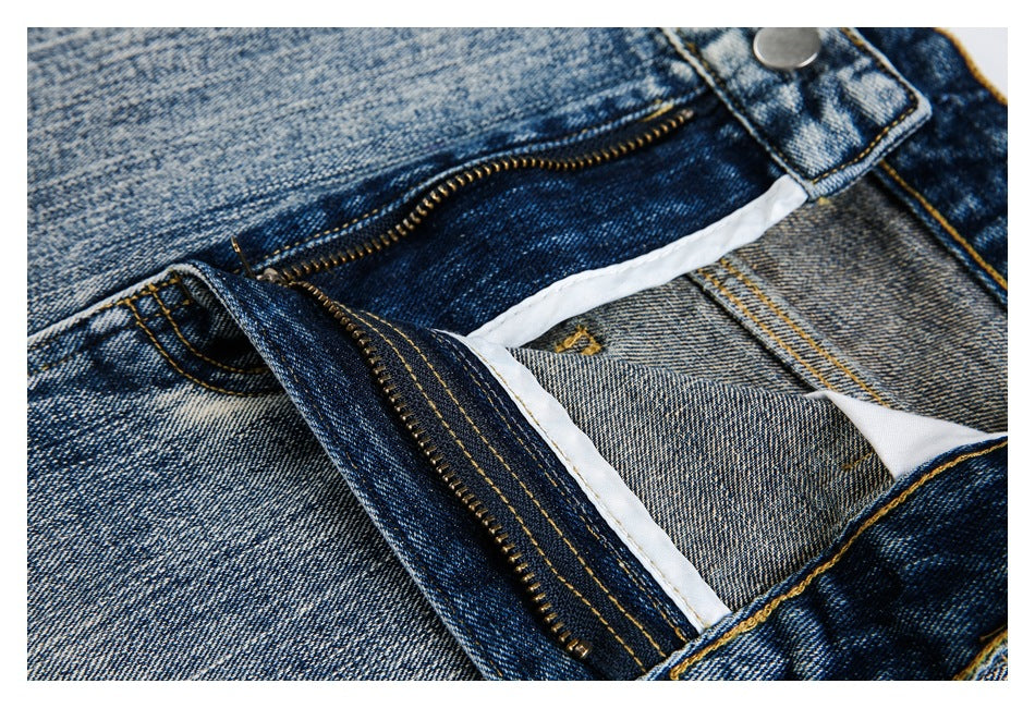 Close-up of the jeans with the front fly unzipped, revealing the zipper, waistband button and inner fabric.
