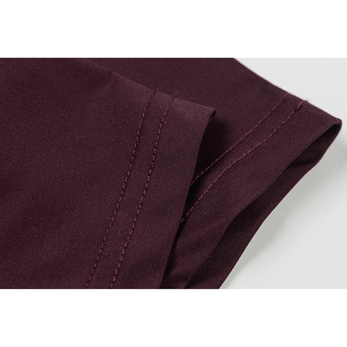 Close-up of the burgundy T-shirt sleeve hem and double-row stitching.