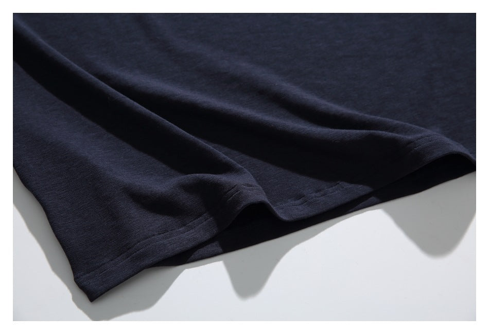Close-up of the dark navy garment's plain hem and double-stitched edge.