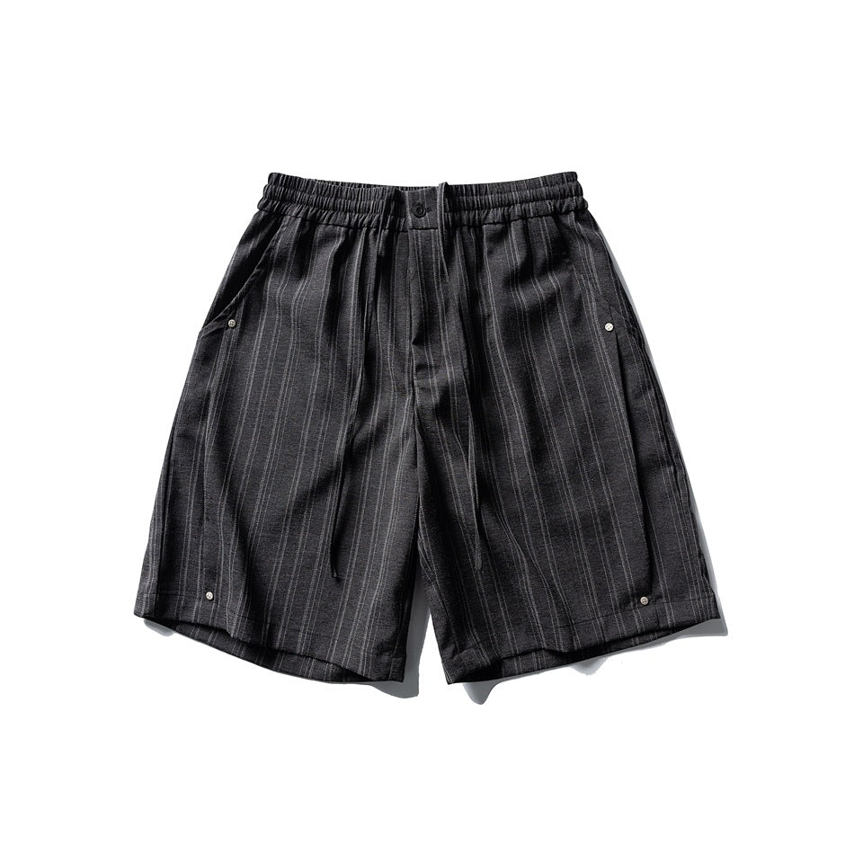 Black pinstriped knee-length shorts with elastic drawstring waist, front button and side studs, flat lay