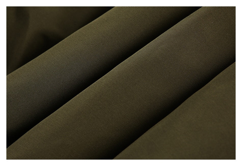 Close-up of dark olive-brown fabric arranged in soft folds, showing its fine texture.