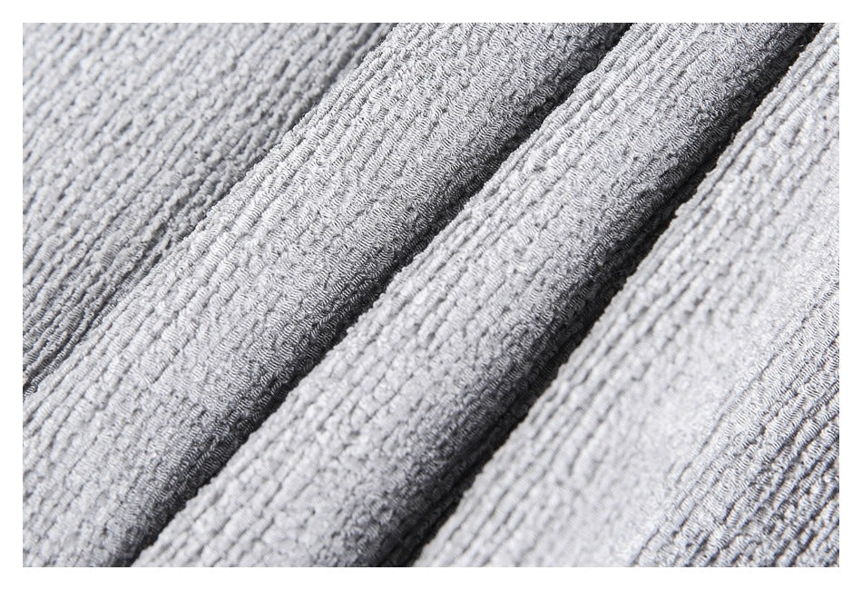 Macro view of light gray textured fabric arranged in parallel folds.