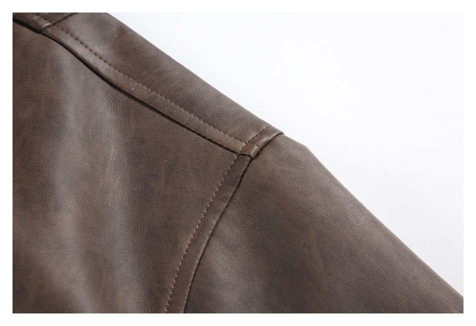 Close-up of the dark brown jacket's shoulder seam and sleeve stitching.