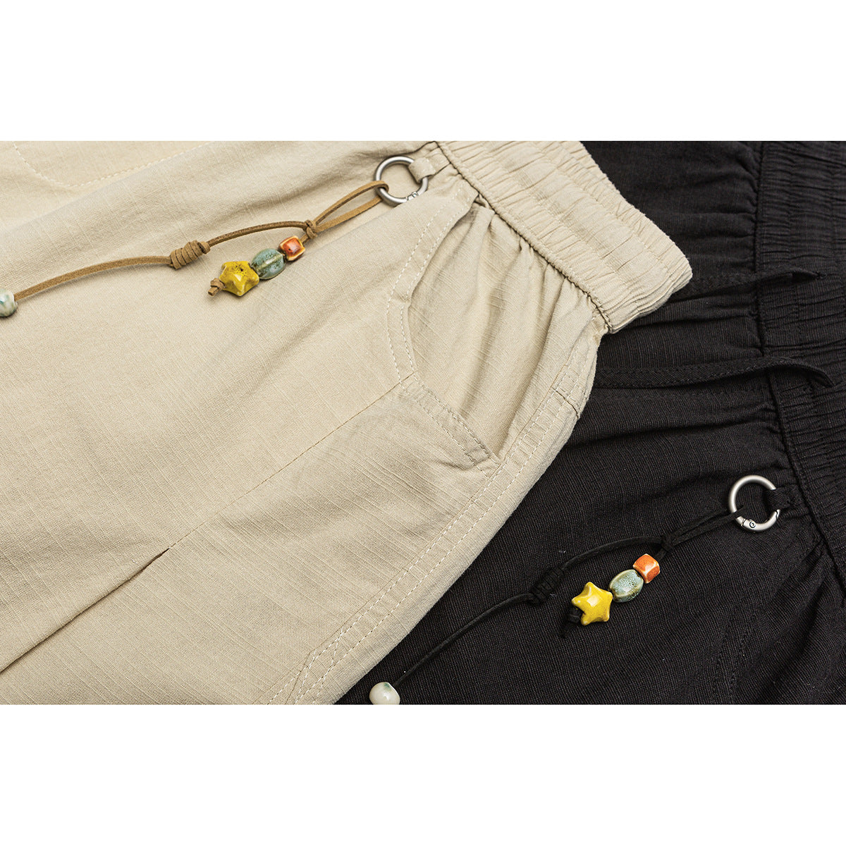 Close-up of beige and black pants waistbands, pockets and decorative beaded drawcords.