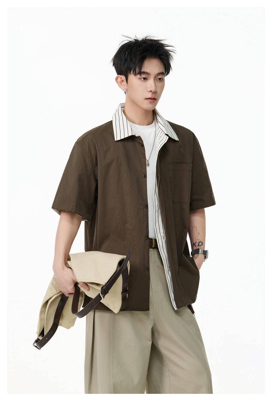 Closer view of a model wearing a dark brown shirt with a striped collar and chest pocket.
