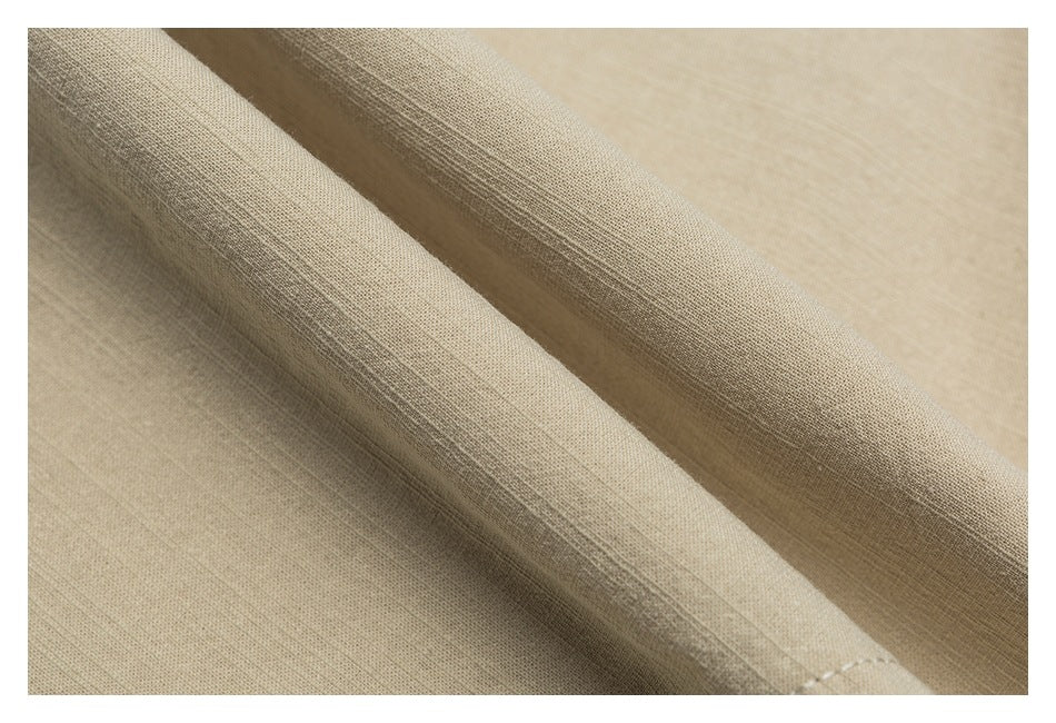 Close-up of beige fabric showing its woven texture and soft folds.
